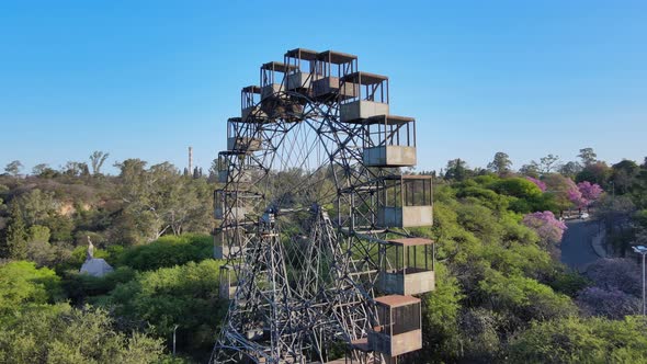 Aerial close up pan shot around idle vintage iron Rueda Eiffel ferris wheel at Sarmiento park, Cordo