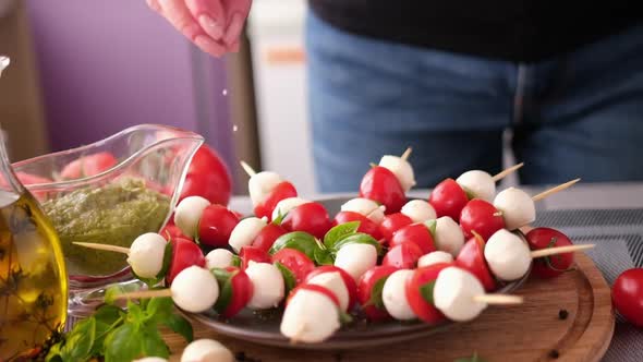 Salting Caprese Canapes with Cherry Tomatoes and Mozzarella Cheese Balls