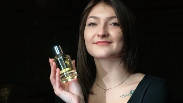 Portrait of a Beautiful Girl with a Perfume Bottle