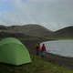 beautiful iceland landscape, two hikers walking together by the lake with a tent pitched in a foregr - VideoHive Item for Sale