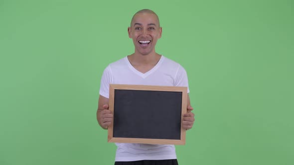 Happy Handsome Bald Man Holding Blackboard and Looking Surprised