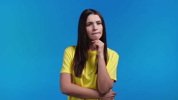 Thinking Woman Looking Up on Blue Studio Background