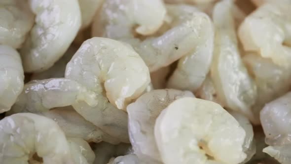Close up of raw peeled shrimp on a brown butcher paper.