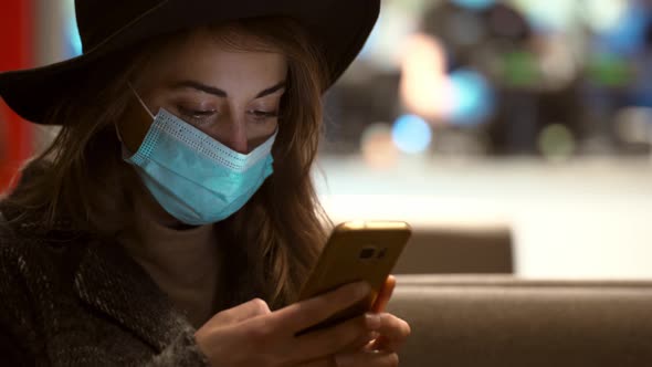 Close Up Woman in Protective Medical Mask Standing Using Smartphone on City Street with Bokeh Lights