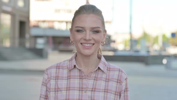 Portrait of Young Woman Smiling at Camera Outdoor