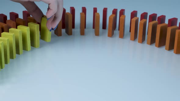 Line up of Dominoes in Rainbow Falling Colors with LGBT Colors of a Hand