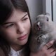 a Young Girl Holding a Rabbit in Her Arms and Sitting By the Window - VideoHive Item for Sale