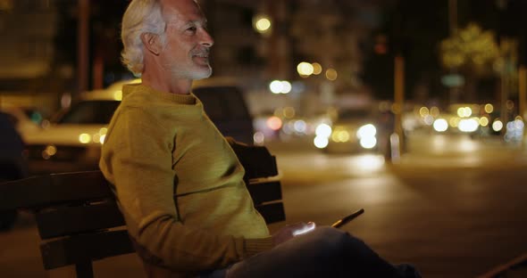 Senior man using digital tablet near street 