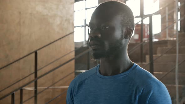 Portrait of black man in blue t-shirt looking at camera indoors