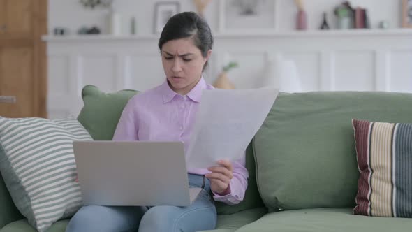 Woman with Laptop having Failure on Documents, Sofa