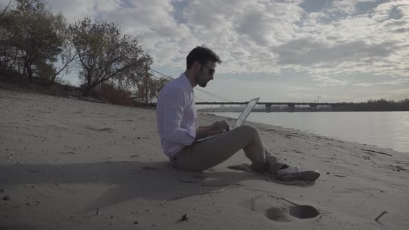 Man Working On Laptop And Sitting On Beach. Creative Man With Computer Overtime Working Outdoor.