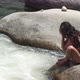 Curly haired lady in bikini washes face with river water - VideoHive Item for Sale