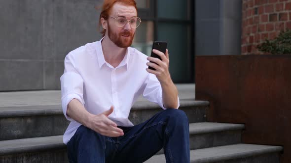 Online Video Chat by Designer Sitting on Office Stairs, Talking