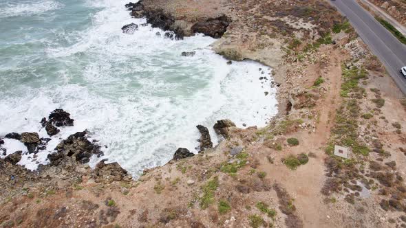 Aerial top view waves break on rocks in a blue ocean. Sea waves on beautiful beach aerial view