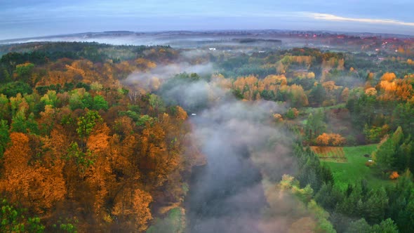 Foggy sunrise at river in autumn, aerial view