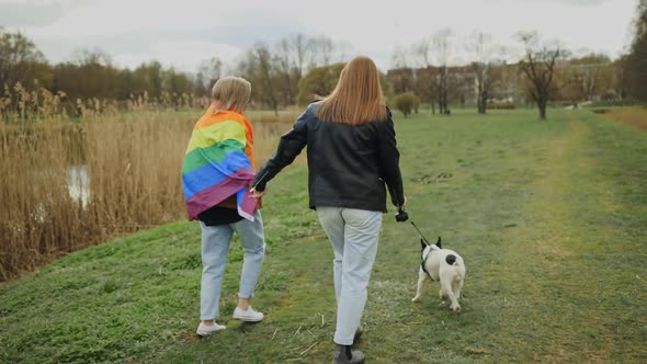 Backside Female LGBT Couple Walking with French Bulldog in Park