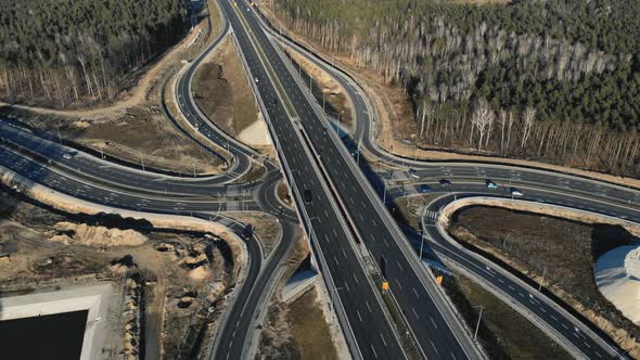 Drone View of Contemporary Elevated Highway Intersection with Vehicles in Woodland in Countryside