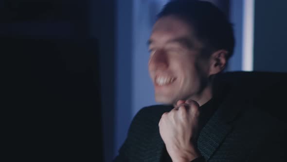 Excited Business Man Read Great News Using Computer Sitting Late at Office at Night