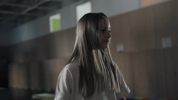 Cute Pupil Girl Jumping in School Hallway Close Up