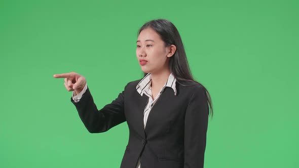 Side View Of An Angry Asian Business Woman Scolding While Standing On Green Screen In The Studio