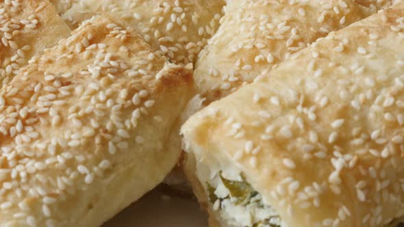 Dough sheets rolls baked with cheese and spinach filling close-up 4K 2160p 30fps UHD tilting footage