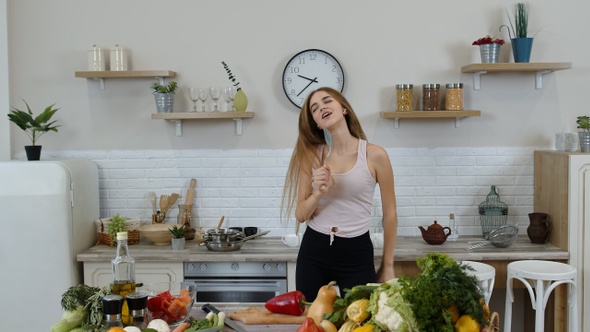 Happy Vegan Girl with Slim Waist Dancing, Singing in Kitchen. Raw Vegetable Nutrition Diet Concept