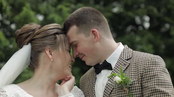 Newlyweds. Caucasian Groom with Bride Walking, Embracing, Hugs in Park. Wedding Couple