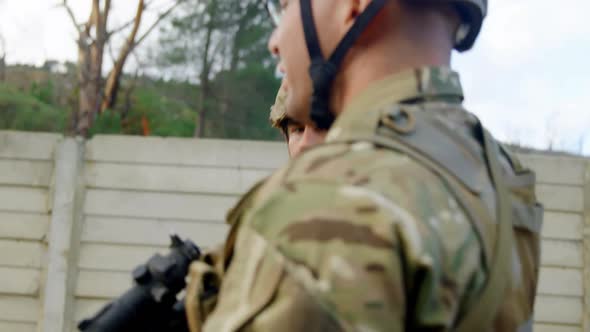 Side view of caucasian military soldiers rifle training in fields during military training 4k