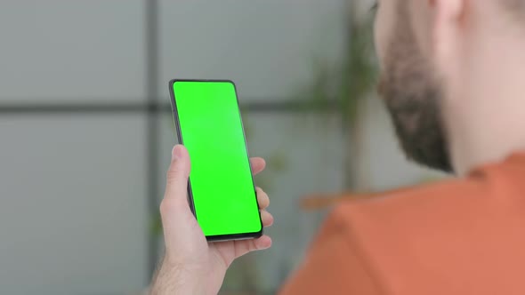 Young Man Using Smartphone with Green Screen