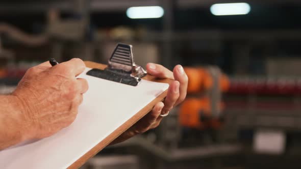 Male worker maintaining records on clipboard