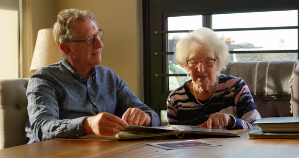 Active senior couple looking at photo album 4k