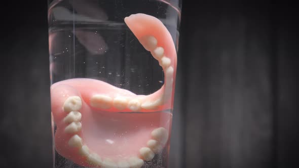 Closeup Shot of Prosthesis Teeth in a Glass of Water