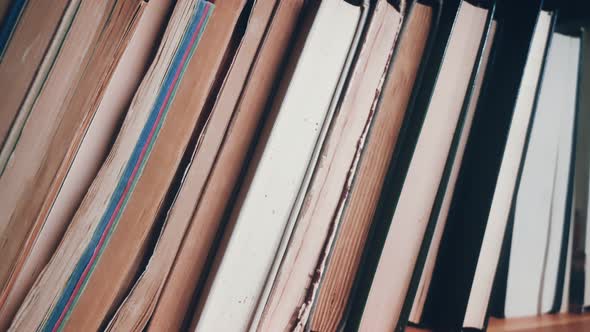 bookcase with old and used books or hardback textbooks visible from above.