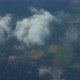 Filming From the Height of an Airplane of Multicolored Fields Through the Clouds - VideoHive Item for Sale