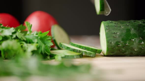 A Man Hands are Cutting a Ripe Green Cucumber