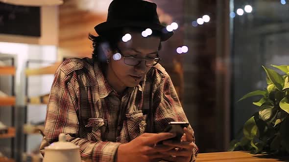 Portrait Of Stylish Man With Mobile Phone At Cafe