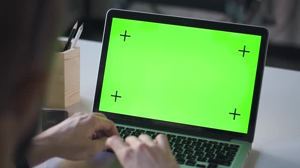 Man Student Working on Laptop Computer with Green Screen at Library Table