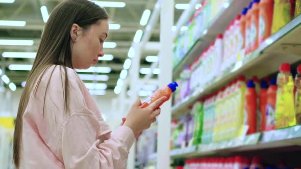 Female Shopper is Reading Labels on Dishwashing Liquid