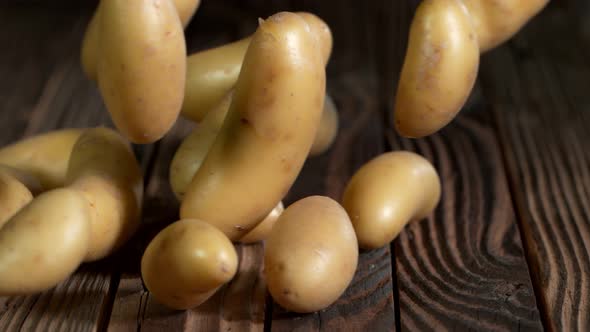 Super Slow Motion Shot of Potatoes Rolling on Old Wooden Table at 1000Fps