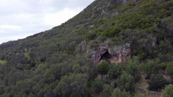 Wonderful aerial view flight fly forwards drone footage to a big scary movie cave in a mountain in t