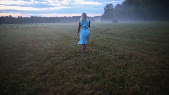 Woman Walking on a Meadow