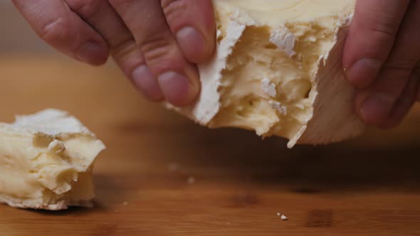 People Cut Cheese with a Knife on Old Wooden Table Break Brie Close Up Macro Cheese