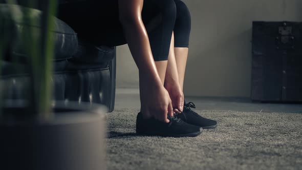 Woman Ties Her Shoes Before Starting Workout at Home or Gym. Active Woman Tying Up Shoelaces During