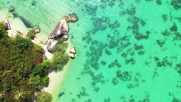 tropical island with white sand and granite rocks in the azure sea water. aerial background