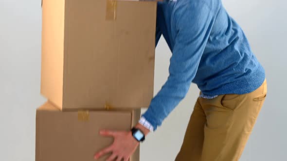 Man carrying stack of cardboard boxes against white background