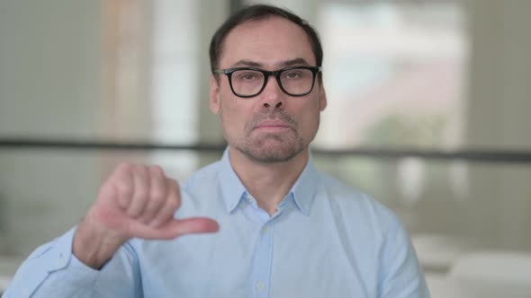 Middle Aged Man Showing Thumbs Down Gesture