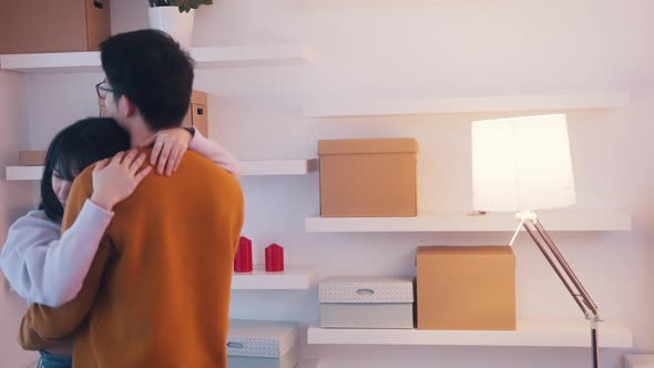 Happy Asian Couple Hugging in the Apartment and Dancing