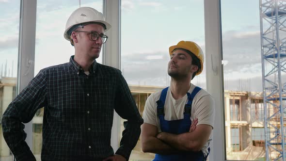 Builders Working Team Looking To Camera at Construction Site. alt