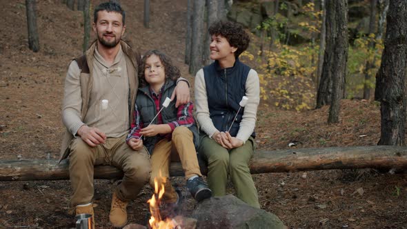 Slow Motion Portrait of Happy People Mom Dad and Kid Sitting Around Fire in Campsite