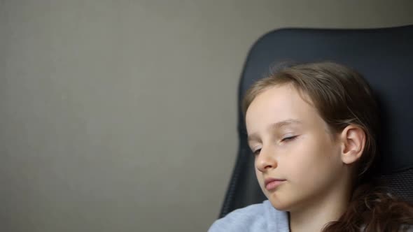 Little Sad Girl is Sitting on Black Office Chair Punishment Serious Face